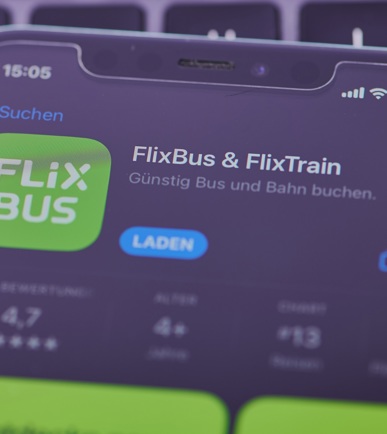 Ein Handy, das auf einem Tisch liegt und die FlixBus & Flixtrain App anzeigend